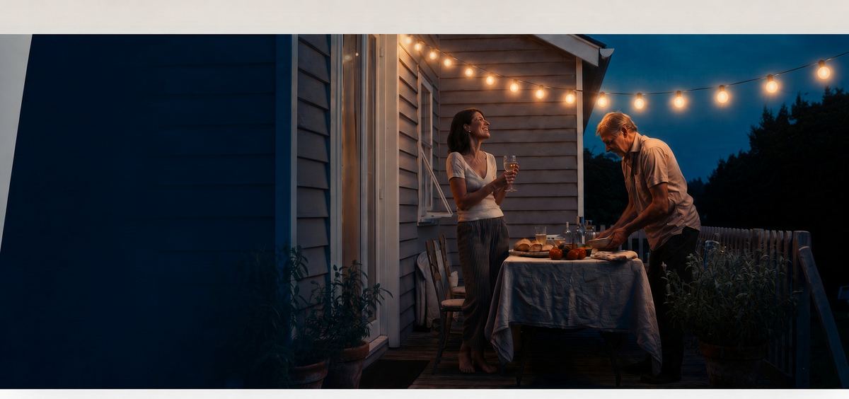 A couple setting an outdoor table for dinner at dusk